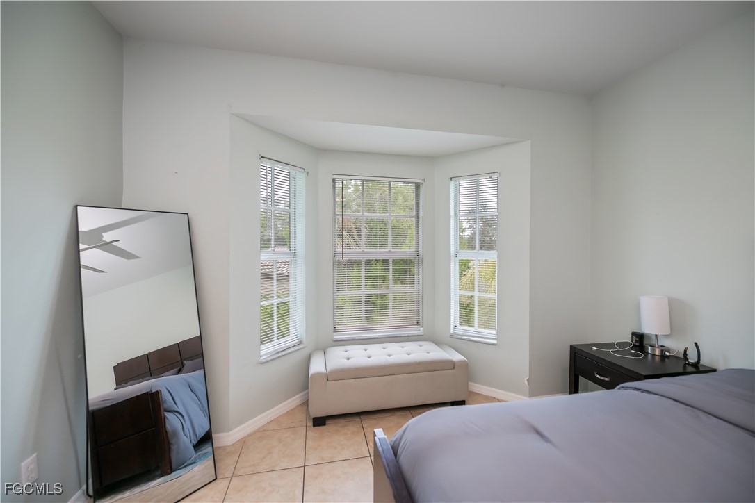 8513 Bernwood Cove Loop, Unit 212 Fort Myers, FL 33966 - Photo 15 of 43 a bedroom with a bed couch and a window