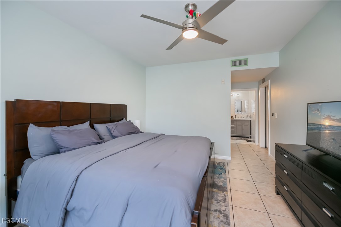 8513 Bernwood Cove Loop, Unit 212 Fort Myers, FL 33966 - Photo 16 of 43 a bedroom with a bed and a chandelier