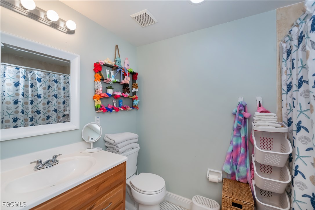 8513 Bernwood Cove Loop, Unit 212 Fort Myers, FL 33966 - Photo 23 of 43 a bathroom with a sink toilet mirror and vanity