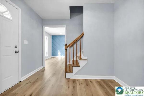 a open kitchen with stainless steel appliances granite countertop a refrigerator a sink dishwasher a oven and white cabinets with wooden floor