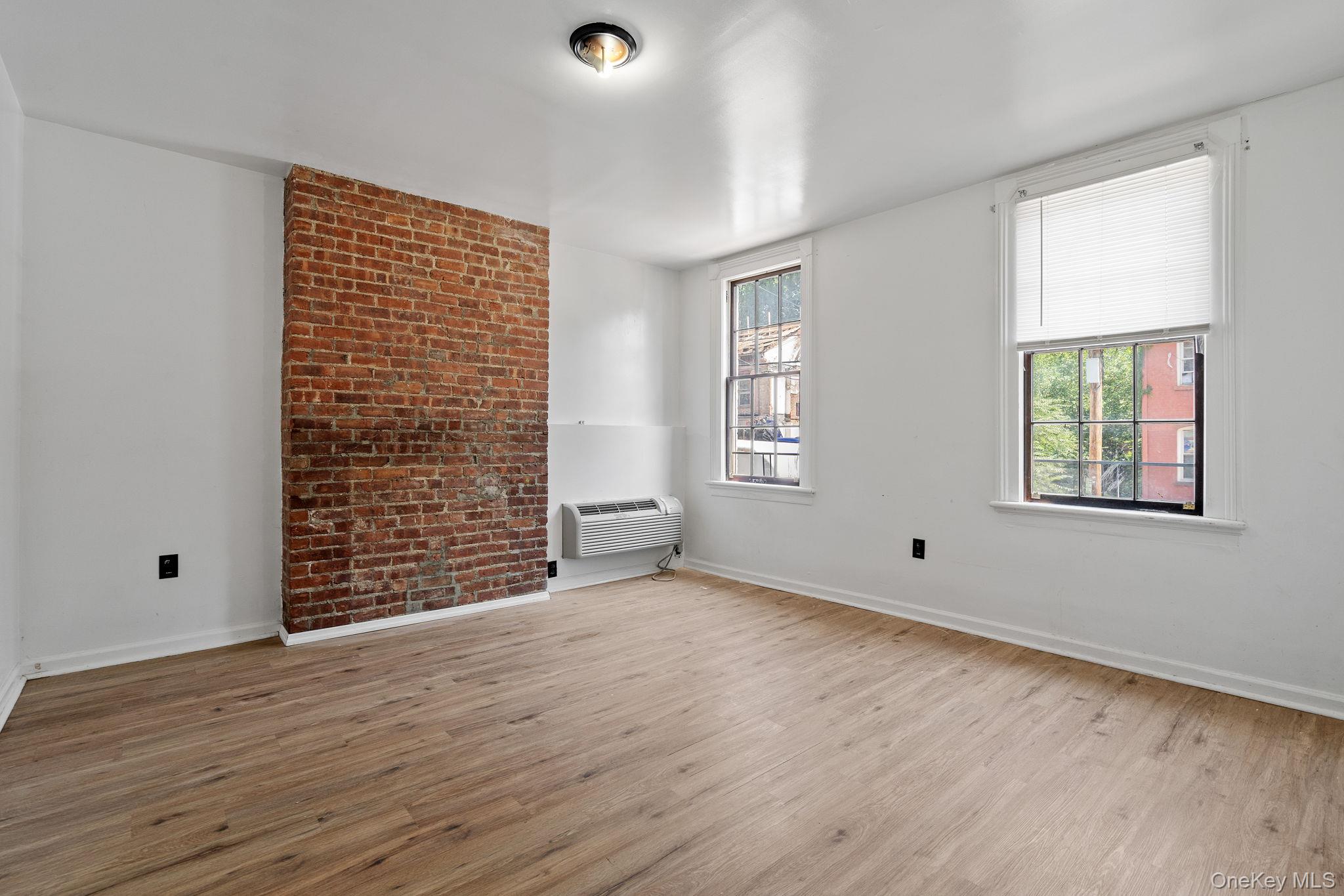 160 Lander Street Newburgh, NY 12550 - Photo 13 of 29 an empty room with wooden floor and windows