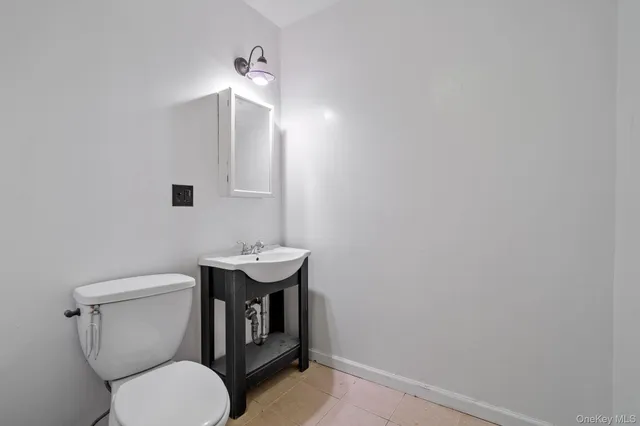 a bathroom with a toilet a sink and mirror