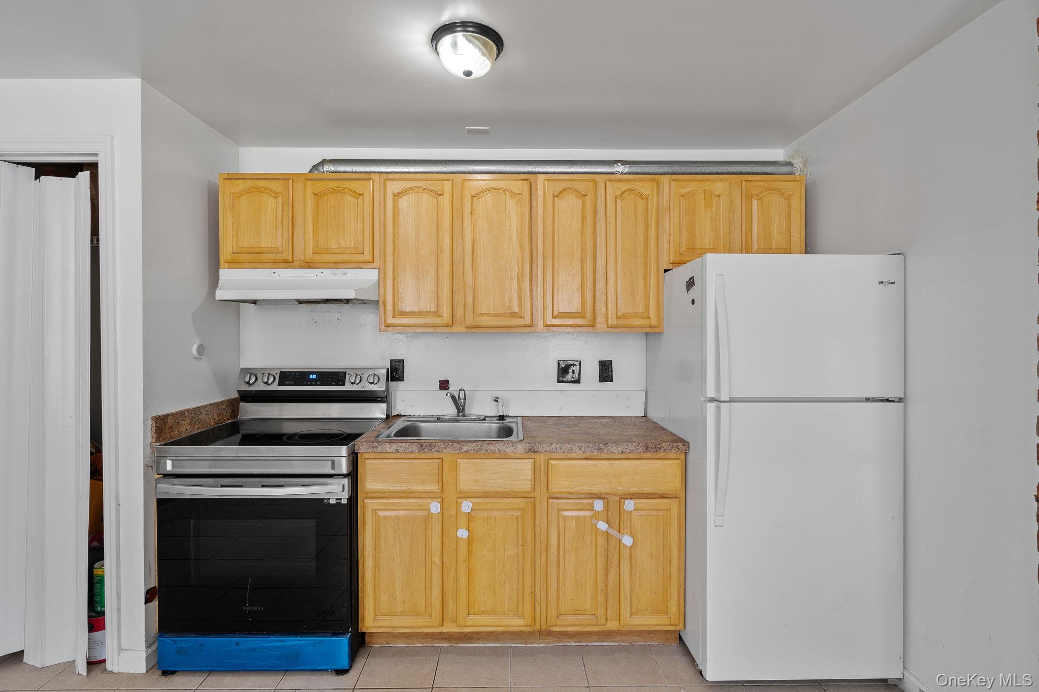 160 Lander Street Newburgh, NY 12550 - Photo 5 of 29 a view of a kitchen with a stove refrigerator and microwave