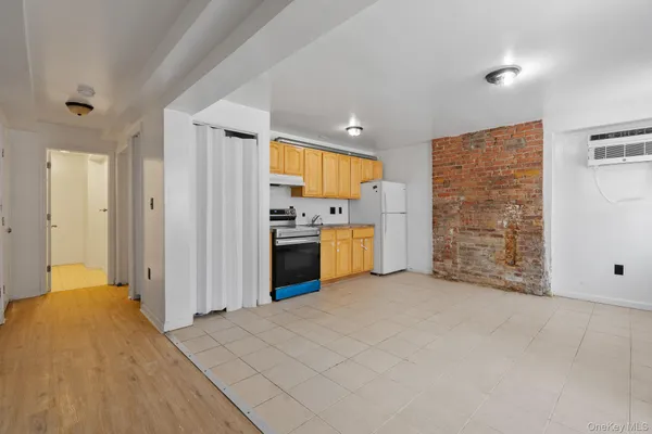 a view of a kitchen with refrigerator stove and wooden floor