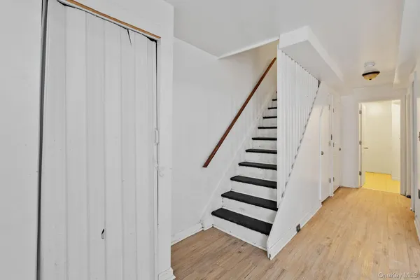 a view of a hallway with wooden floor and entryway