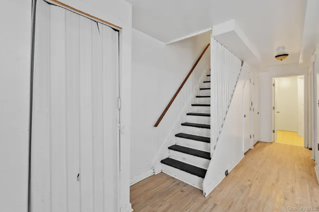 a view of a hallway with wooden floor and entryway