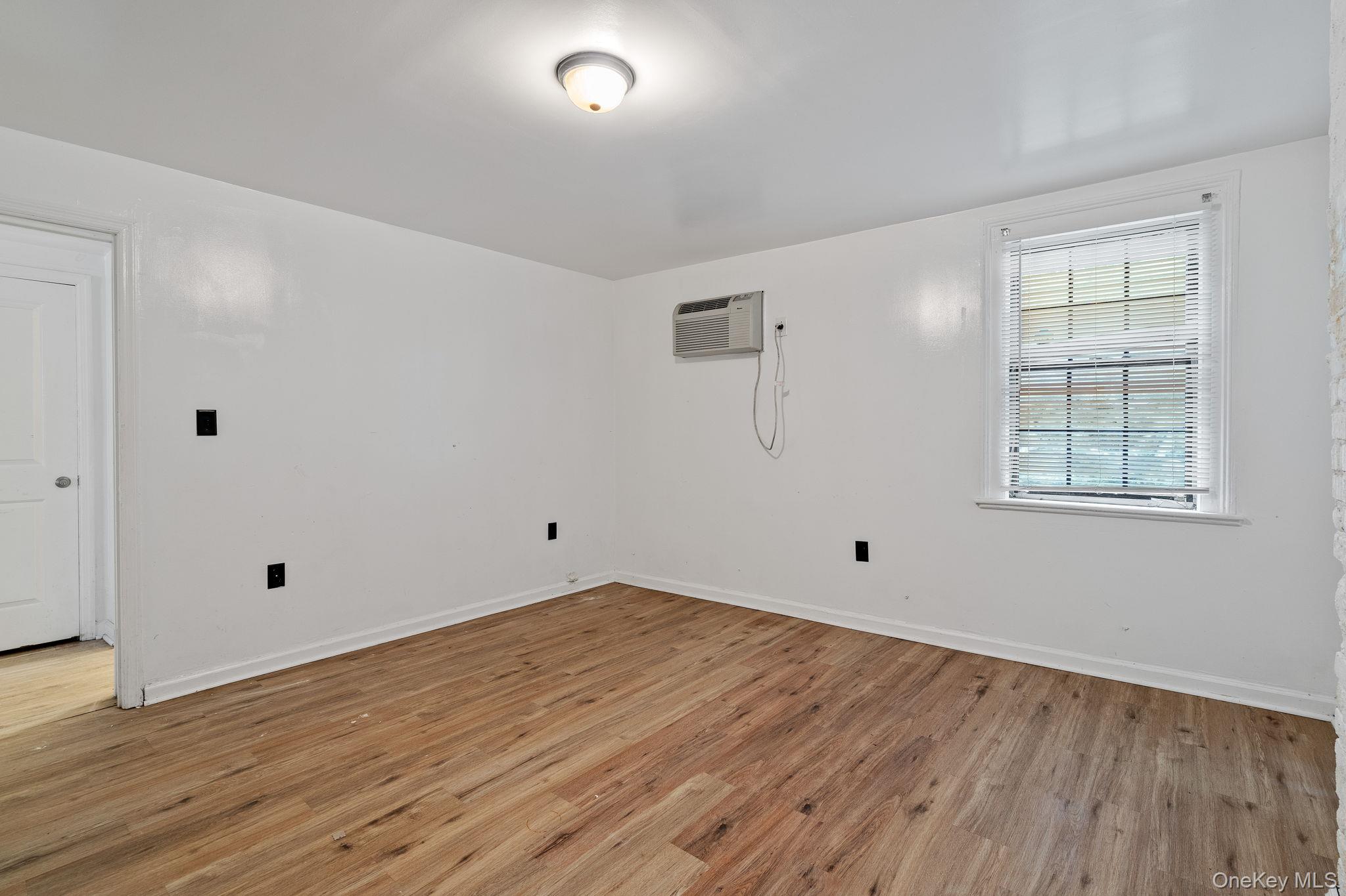 160 Lander Street Newburgh, NY 12550 - Photo 10 of 29 an empty room with wooden floor and windows