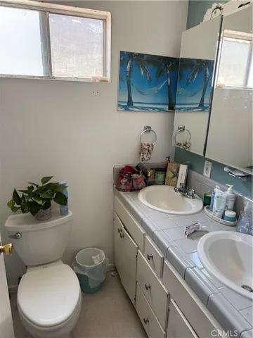 a bathroom with a granite countertop toilet sink and mirror