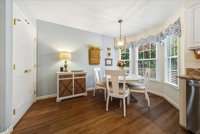 a dining room with furniture a chandelier and wooden floor