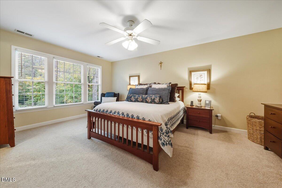 617 Rodney Bay Crossing Wake Forest, NC 27587 - Photo 19 of 36 a bedroom with a large bed and a chandelier fan