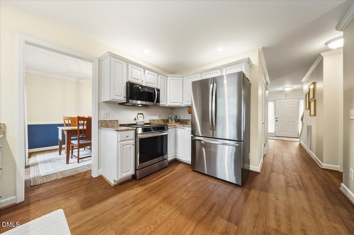 617 Rodney Bay Crossing Wake Forest, NC 27587 - Photo 10 of 36 a kitchen with a refrigerator stove and wooden floor