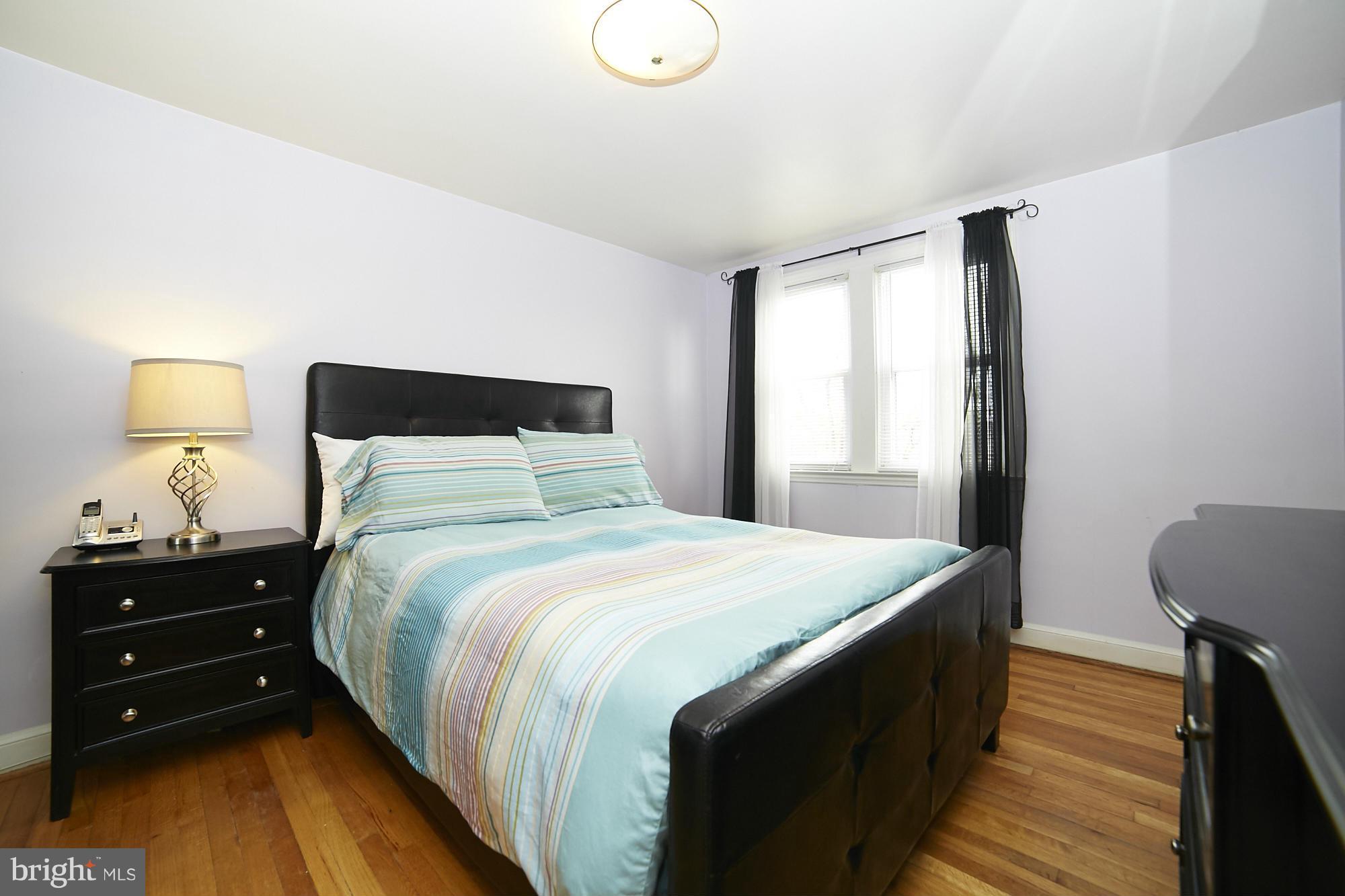 4936 West Hills Road Baltimore, MD 21229 - Photo 12 of 18 a bedroom with a bed and a lamp on dresser