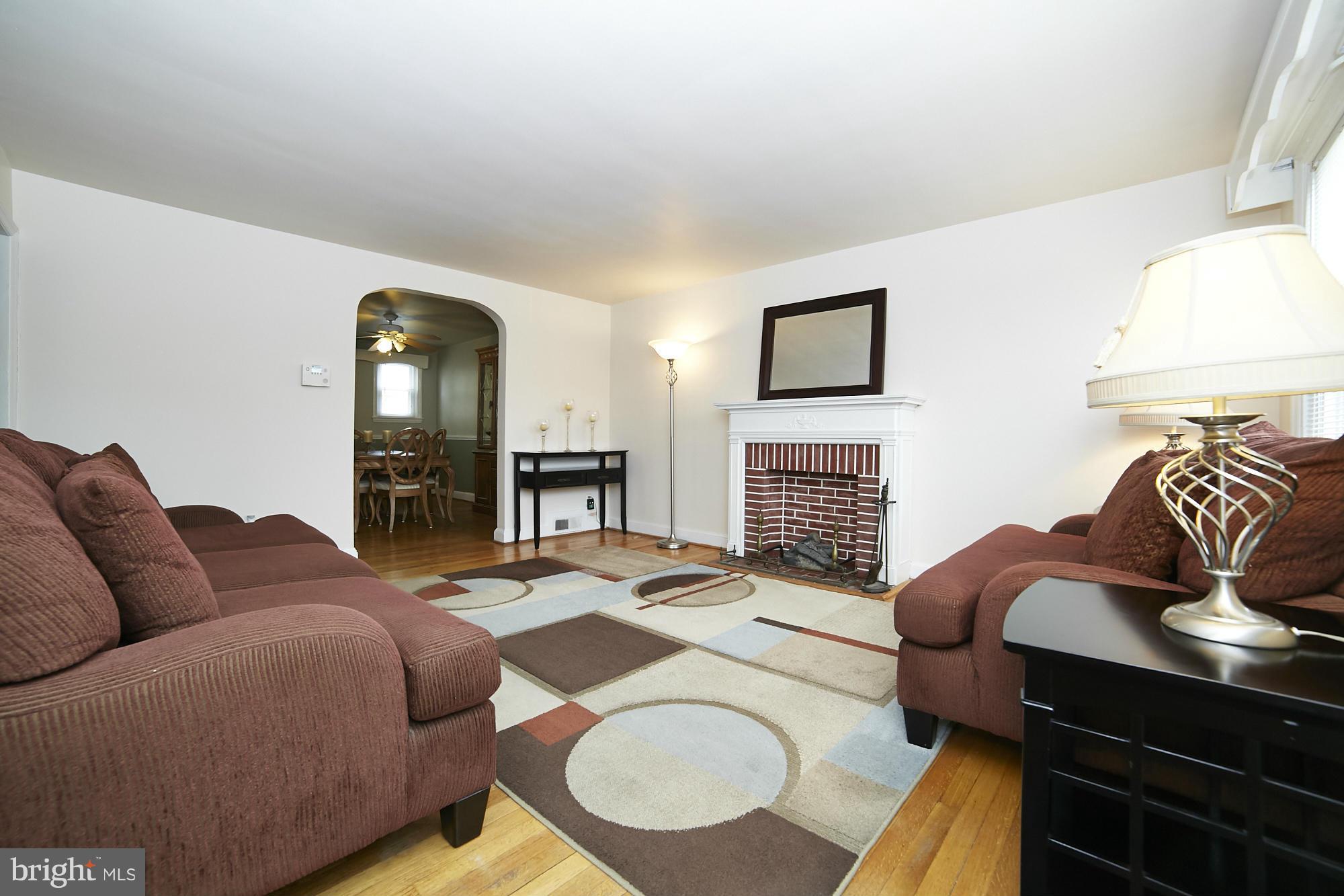 4936 West Hills Road Baltimore, MD 21229 - Photo 3 of 18 a living room with furniture a fireplace and a flat screen tv