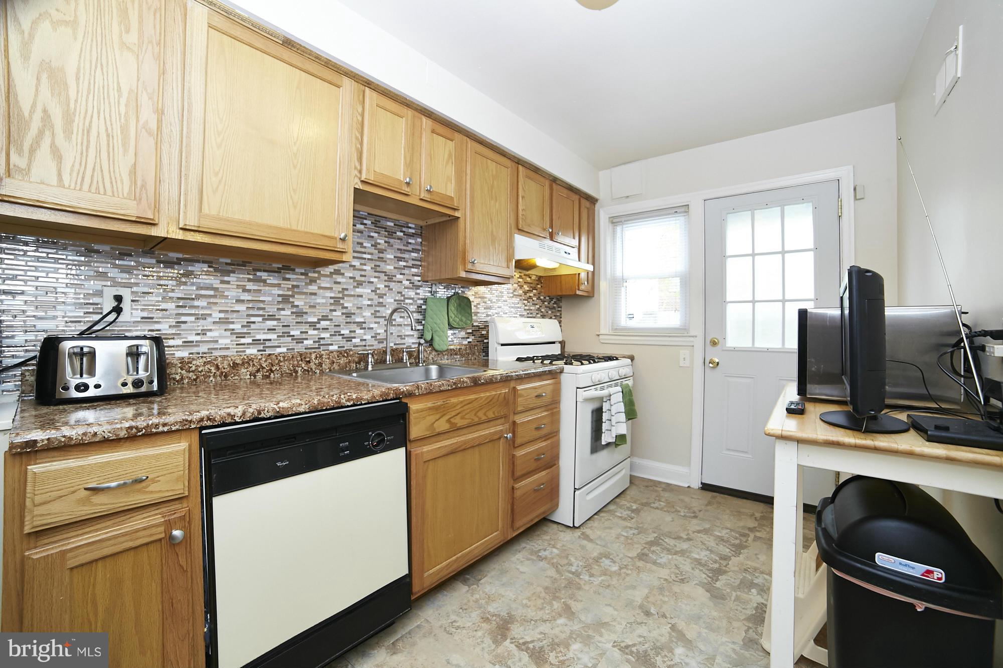 4936 West Hills Road Baltimore, MD 21229 - Photo 6 of 18 a kitchen with white cabinets and appliances