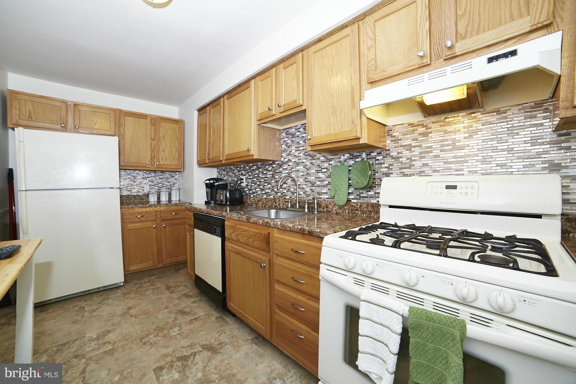 4936 West Hills Road Baltimore, MD 21229 - Photo 7 of 18 a kitchen with a stove a refrigerator and cabinets