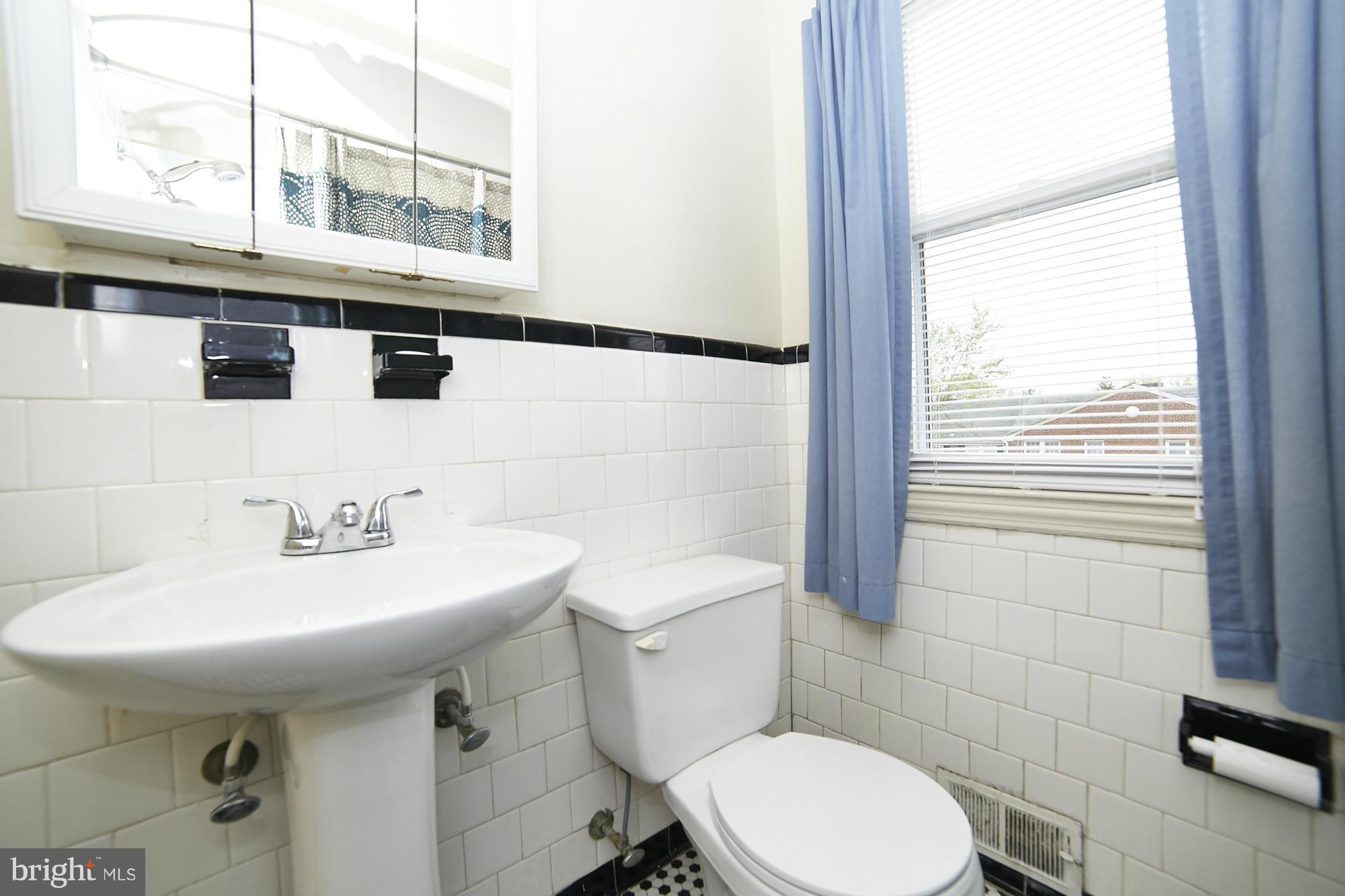 4936 West Hills Road Baltimore, MD 21229 - Photo 10 of 18 a bathroom with a sink a toilet and mirror