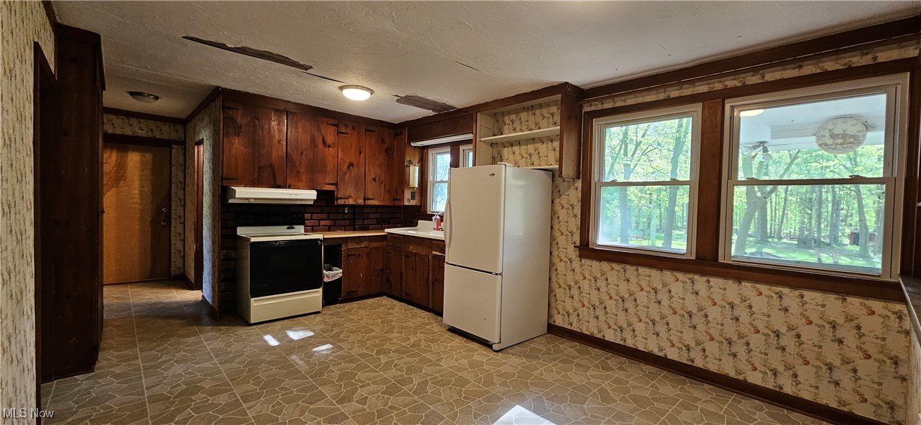 7836 Beach Road Wadsworth, OH 44281 - Photo 11 of 22 Kitchen featuring refrigerator, range with electric stovetop, under cabinet range hood, light countertops, and open shelves
