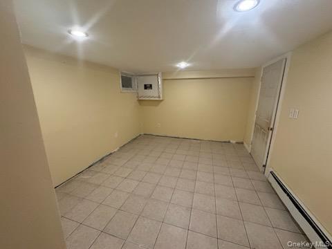 61 Wheeler Road Central Islip, NY 11722 - Photo 21 of 26 an empty room with white walls and tiles