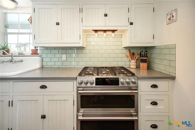 a stove top oven sitting inside of a kitchen