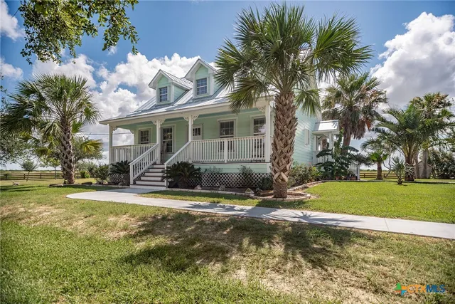 a view of a house with a yard and tree s