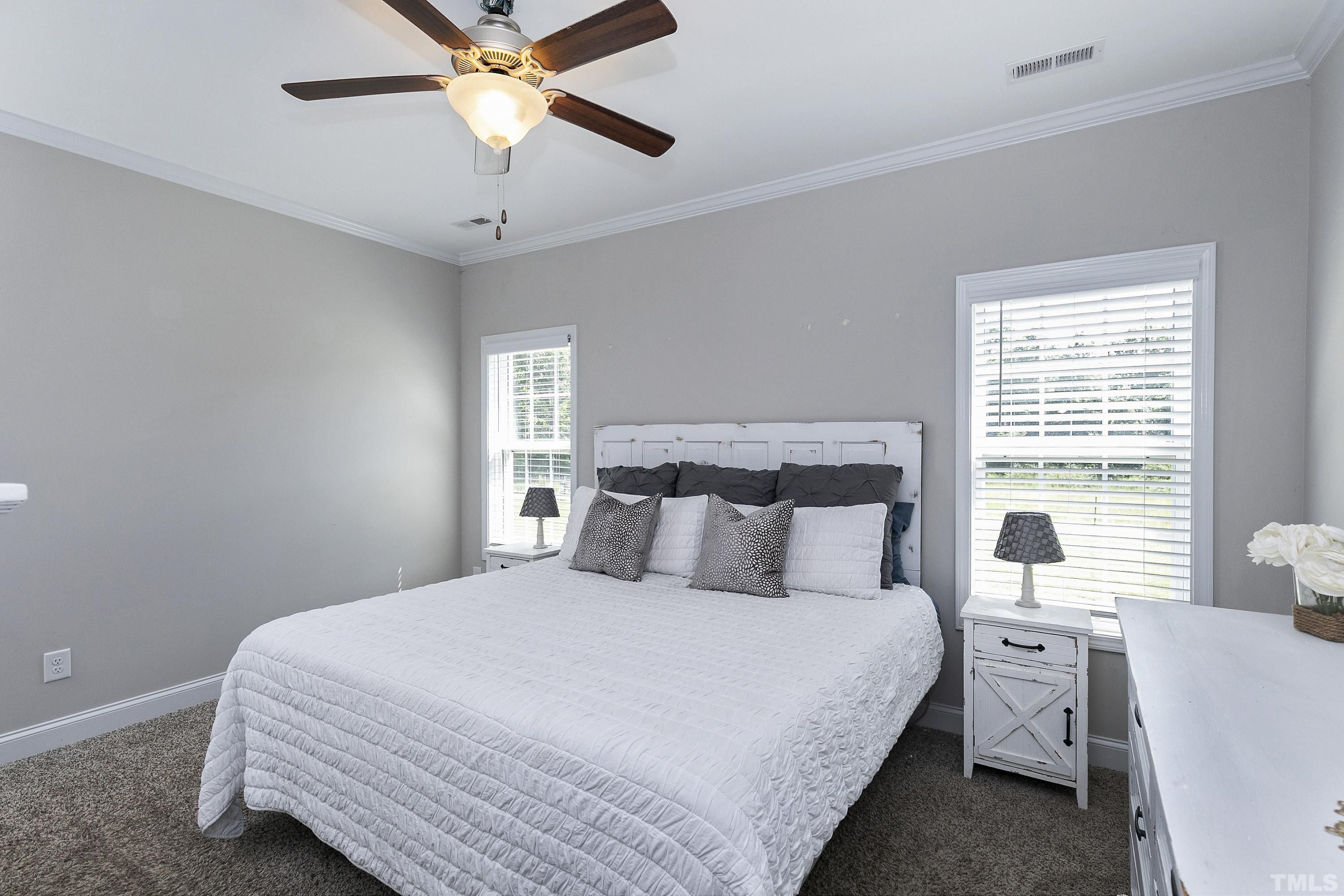 7163 Highway 210 Bunnlevel, NC 28323 - Photo 22 of 54 a bedroom with a large bed and a chandelier