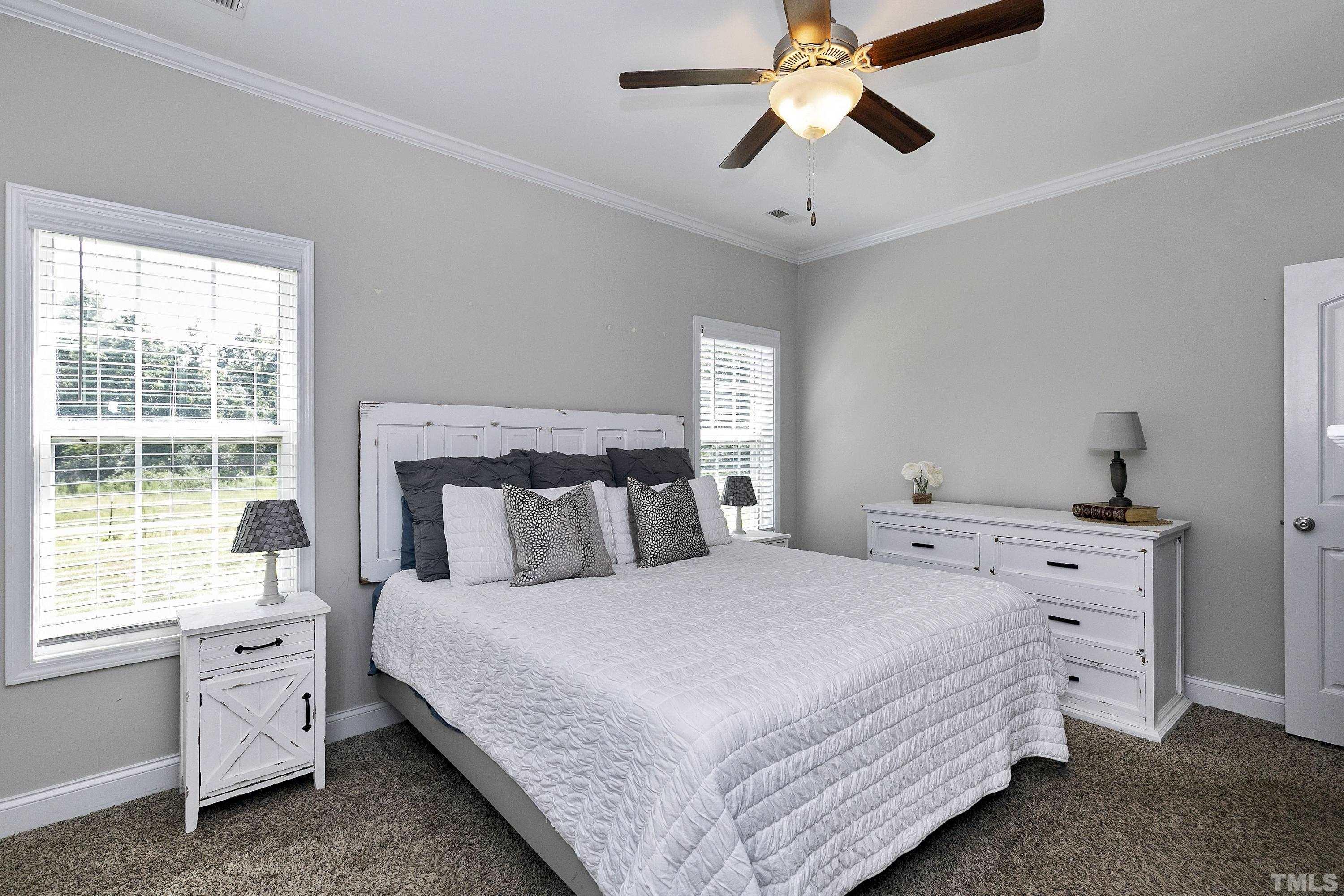 7163 Highway 210 Bunnlevel, NC 28323 - Photo 23 of 54 a bedroom with a bed and a chandelier fan