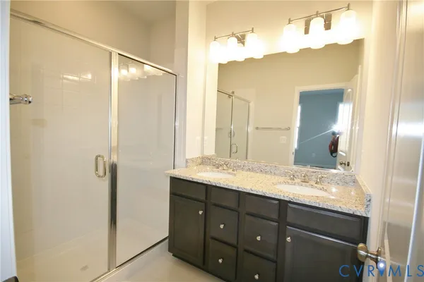 a bathroom with a granite countertop sink shower and a mirror