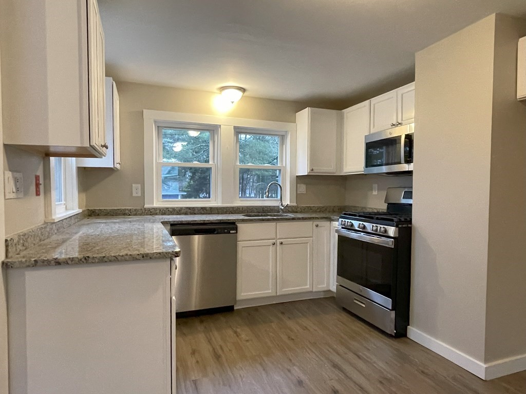 87 Cohasset Road Wareham, MA 02532 - Photo 5 of 16 a kitchen with stainless steel appliances granite countertop a stove a sink and a microwave
