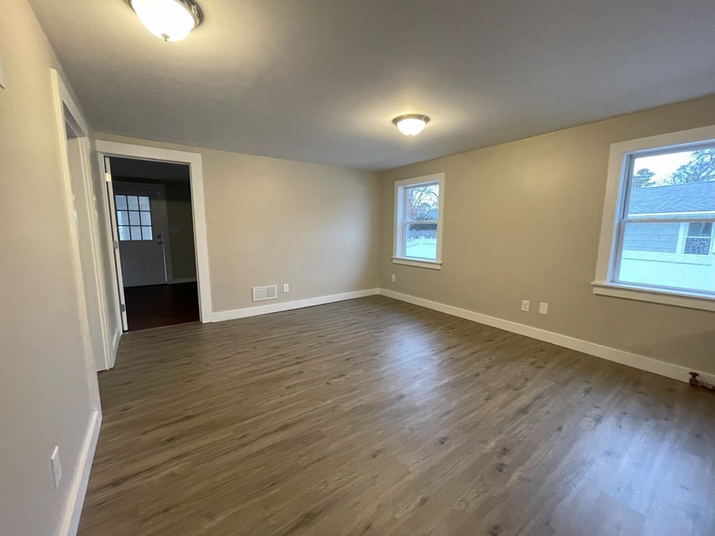 87 Cohasset Road Wareham, MA 02532 - Photo 8 of 16 an empty room with wooden floor and windows