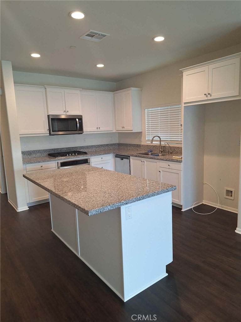 35170 Webb Place Beaumont, CA 92223 - Photo 5 of 21 a kitchen with stainless steel appliances granite countertop a stove top oven a sink and a refrigerator