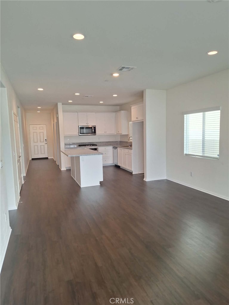 35170 Webb Place Beaumont, CA 92223 - Photo 6 of 21 a open kitchen with kitchen island a sink dishwasher a stove and a refrigerator with wooden floor