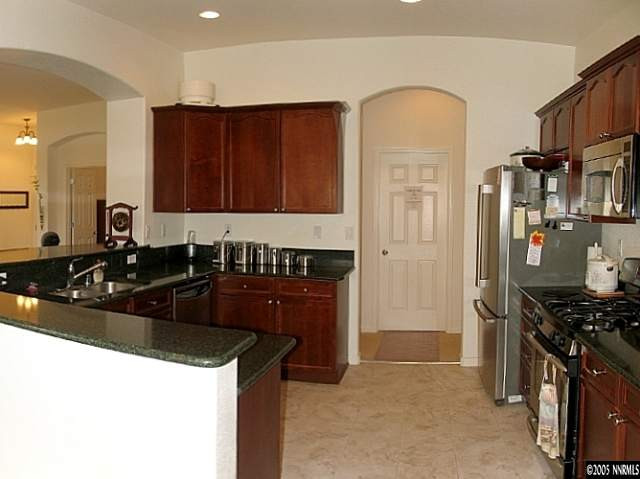 2595 Perryville Drive Reno, NV 89521 - Photo 3 of 9 a kitchen with stainless steel appliances granite countertop a sink stove and refrigerator