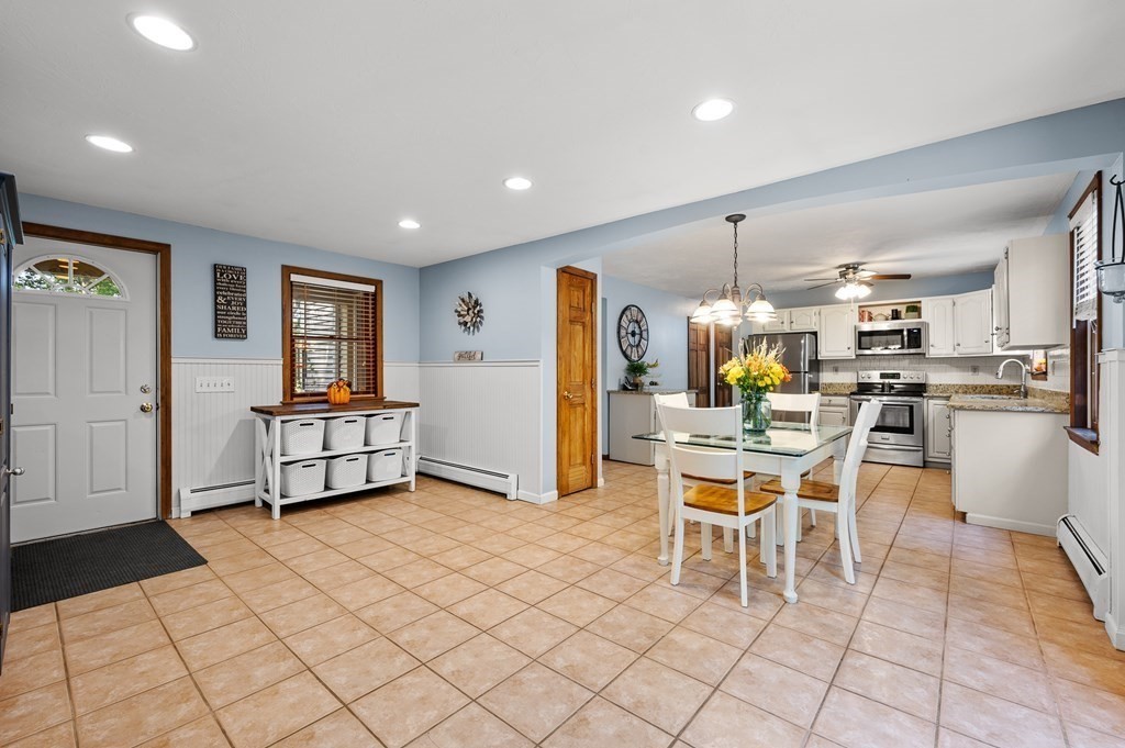 152 Warren Road Brimfield, MA 01010 - Photo 3 of 33 a dining room with stainless steel appliances kitchen island granite countertop a table and chairs in it