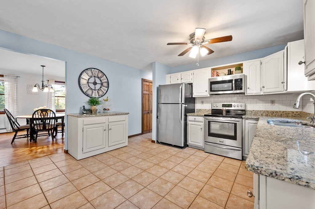 152 Warren Road Brimfield, MA 01010 - Photo 6 of 33 a kitchen with a refrigerator a stove top oven a clock and a window