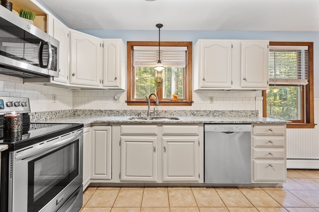 152 Warren Road Brimfield, MA 01010 - Photo 7 of 33 a kitchen with granite countertop white cabinets stainless steel appliances a sink and a window