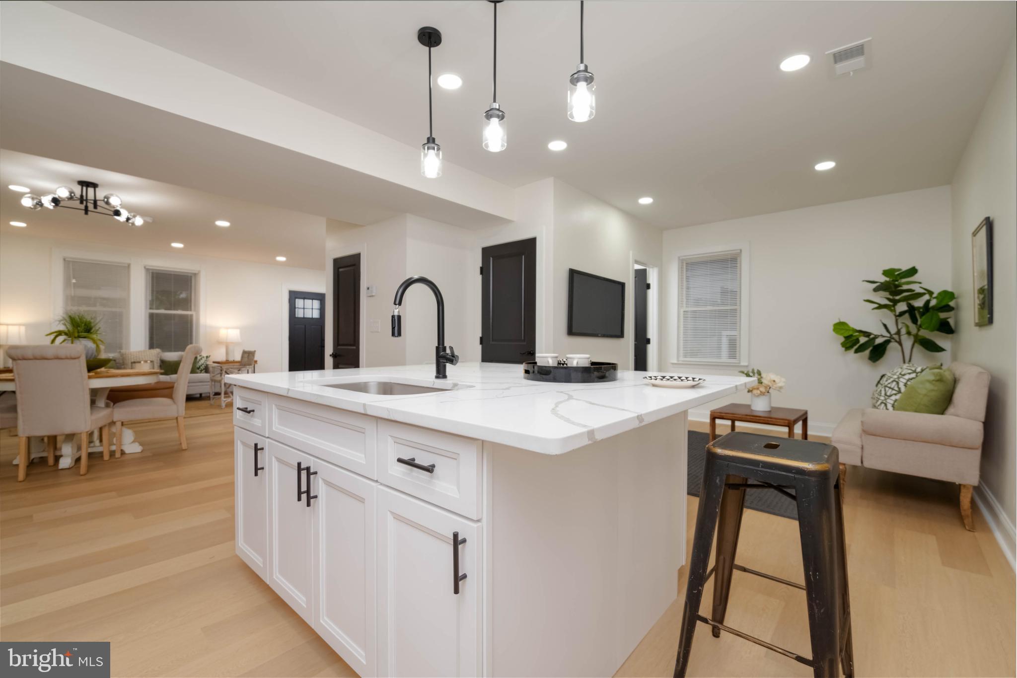 a large kitchen with kitchen island a sink a stove a dining table and chairs