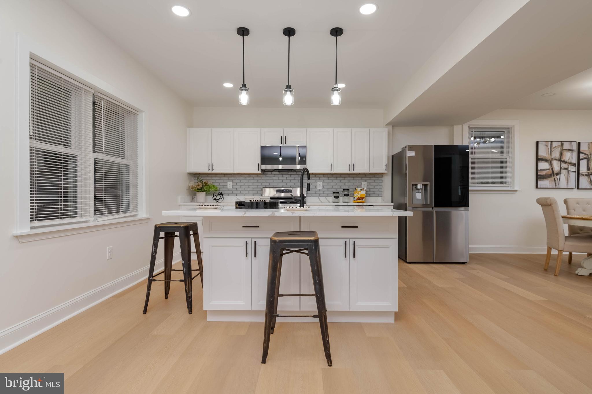 1117 Overbrook Road Baltimore, MD 21239 - Photo 12 of 37 a kitchen with stainless steel appliances granite countertop a stove a refrigerator a oven a sink a island with a dining table and chairs