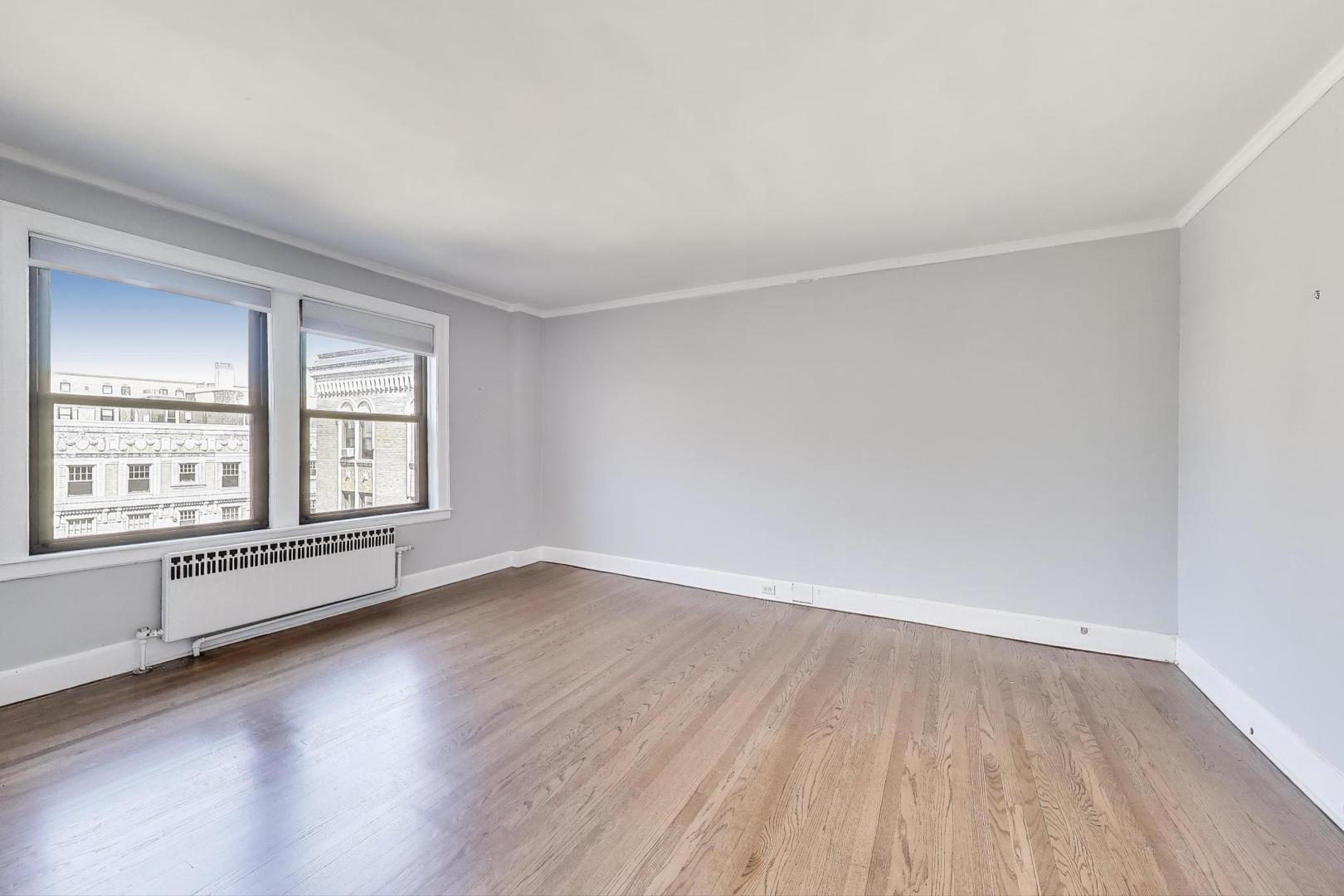 1755 East 55th Street, Unit 1204 Chicago, IL 60615 - Photo 13 of 19 an empty room with wooden floor and windows