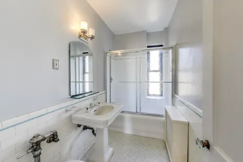 a bathroom with a tub sink and mirror