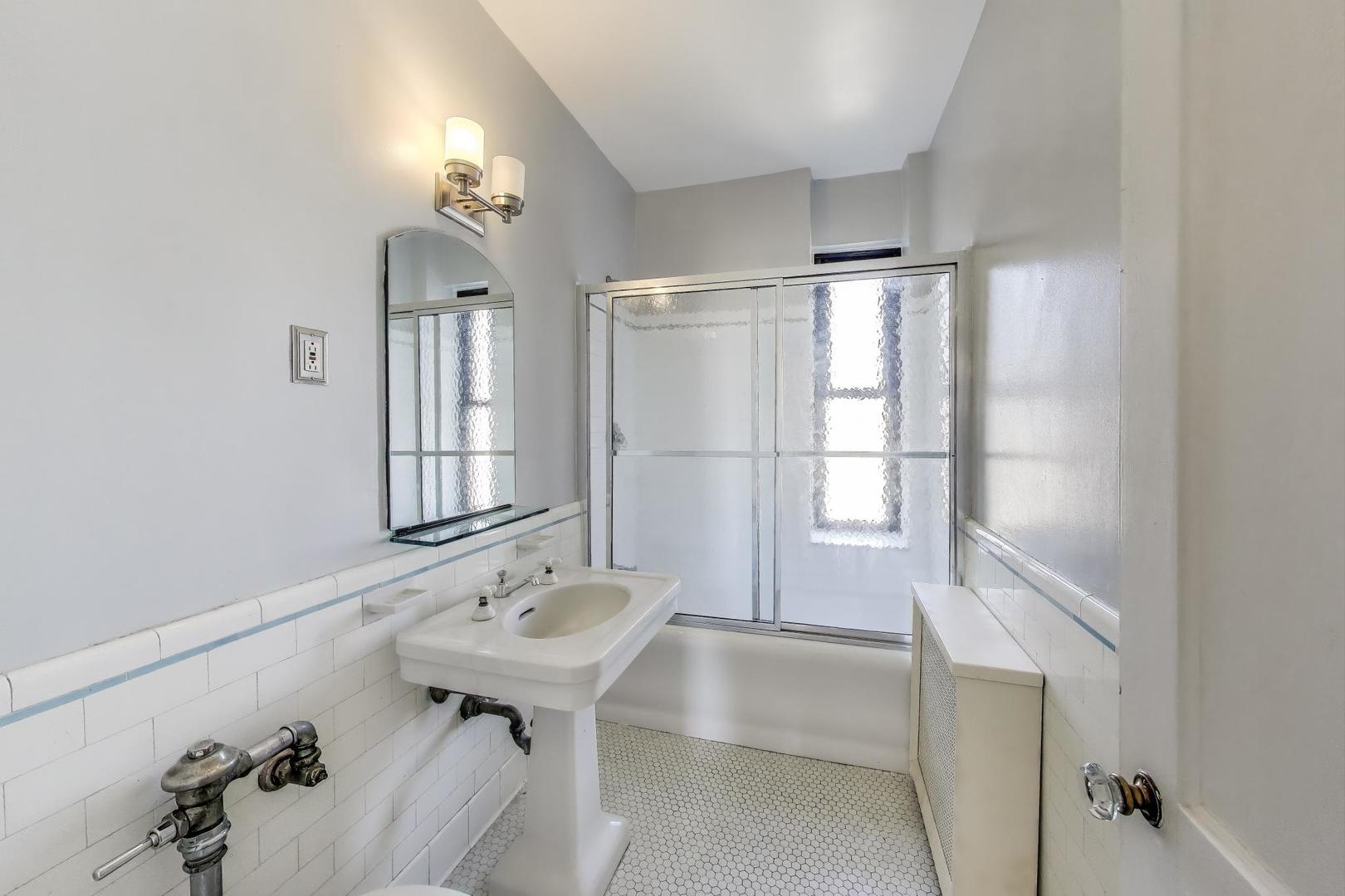 1755 East 55th Street, Unit 1204 Chicago, IL 60615 - Photo 15 of 19 a bathroom with a tub sink and mirror