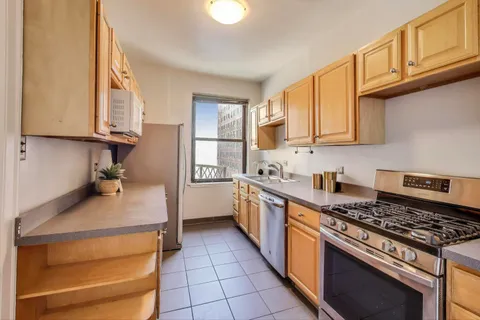 a kitchen with kitchen island granite countertop a stove and a sink
