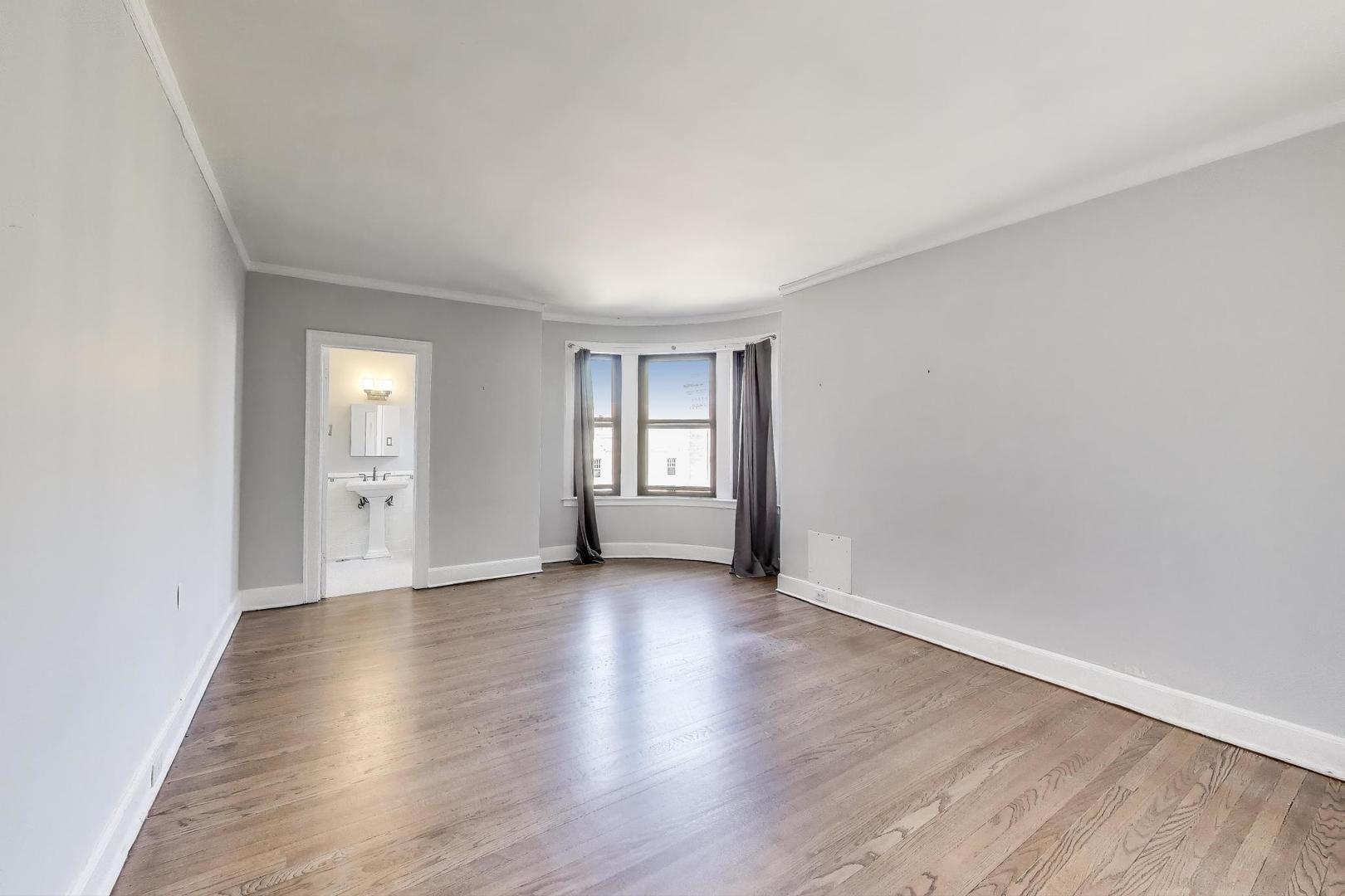 1755 East 55th Street, Unit 1204 Chicago, IL 60615 - Photo 10 of 19 a view of an empty room with window and wooden floor
