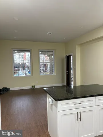 an empty room with wooden floor and cabinet