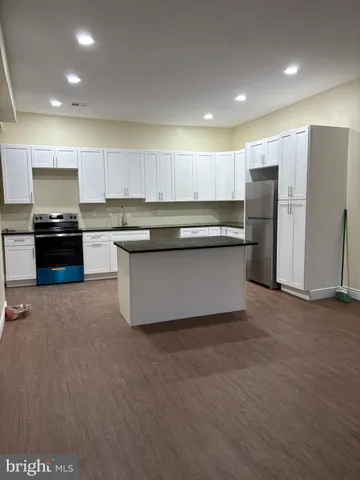 a kitchen with stainless steel appliances granite countertop a refrigerator and a stove top oven