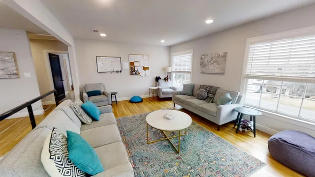 a living room with furniture a rug and a large window