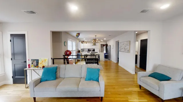 a living room with furniture and a view of kitchen