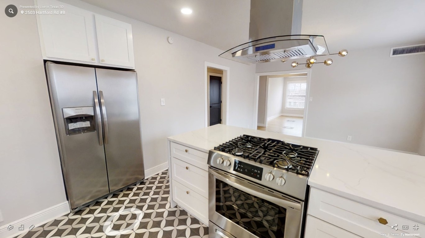 2503 Hartford Road, Unit B Austin, TX 78703 - Photo 5 of 14 Kitchen with stainless steel appliances, white cabinetry, and island range hood