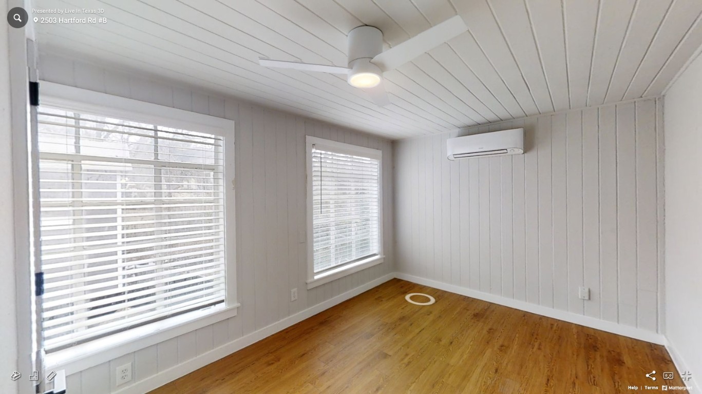 2503 Hartford Road, Unit B Austin, TX 78703 - Photo 9 of 14 Spare room with light wood-style floors, a wall unit AC, wooden walls, wooden ceiling, and ceiling fan