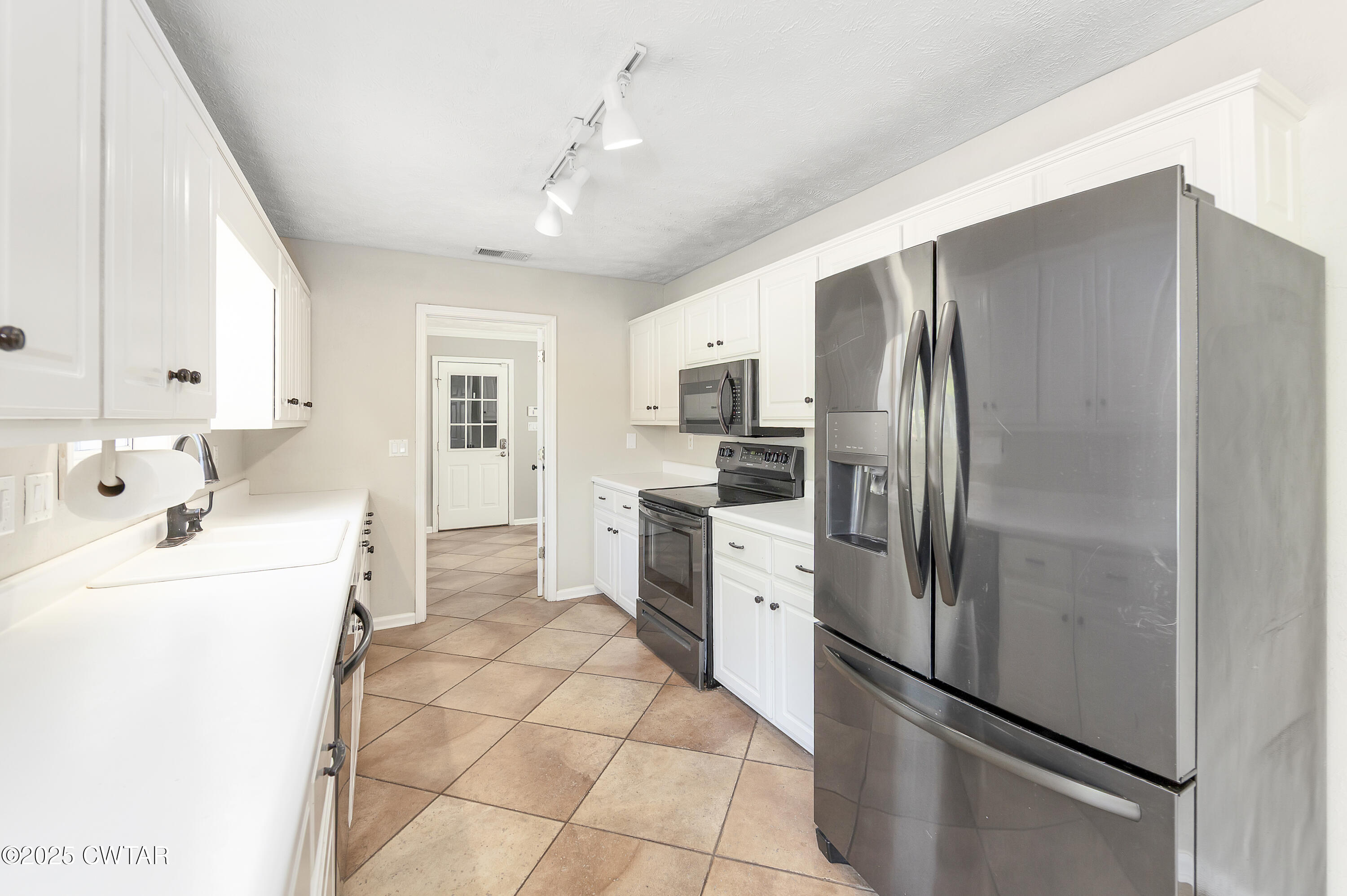 175 Willow Branch Drive Jackson, TN 38305 - Photo 14 of 39 a kitchen with stainless steel appliances a refrigerator sink and cabinets
