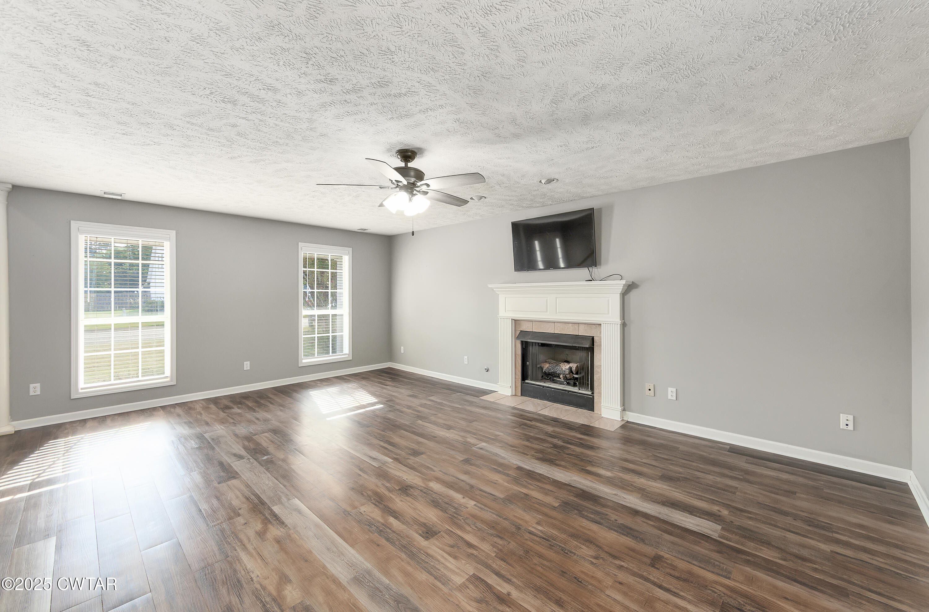 175 Willow Branch Drive Jackson, TN 38305 - Photo 5 of 39 a view of an empty room with wooden floor fireplace and a window